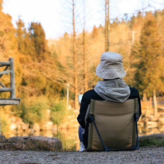Chaise-de-camping-beige-personne-en-randonnee