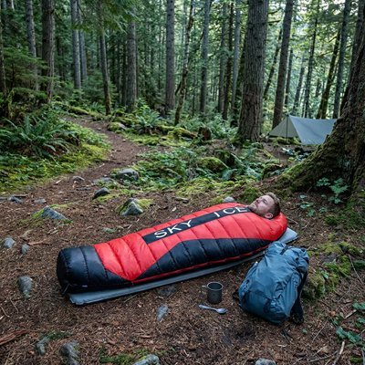 Homme en foret avec sont Sac de couchage pour grand froid 